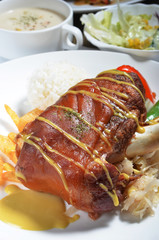 German BBQ pork knuckle and rice on white plate 