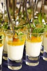 Creamy dessert and salted caramel ice cream in glass jars with fresh mint.