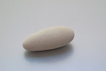 Fototapeta na wymiar Sea smooth stone on a light background