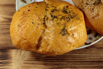 Fresh bread ciabatta on a plate on wooden table