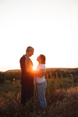 Couple holding hands at sunset enjoying romance and sun.