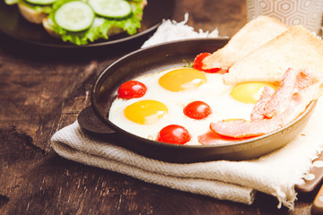 breakfast with eggs, cherry tomatoes, bacon and fresh toasted toast