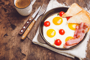 breakfast with eggs, cherry tomatoes, bacon and fresh toasted toast