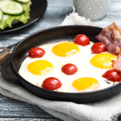 breakfast with eggs, cherry tomatoes, bacon and fresh toasted toast