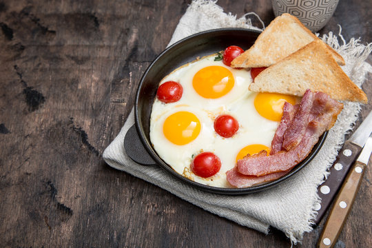 breakfast with eggs, cherry tomatoes, bacon and fresh toasted toast