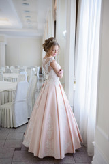 Fototapeta premium A beautiful woman in a pink wedding dress in a big festive hall