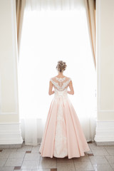 Fototapeta premium A beautiful woman in a pink wedding dress in a big festive hall