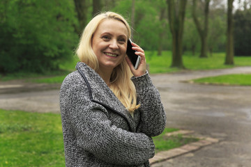 Beautiful woman in park speaks on the phone.