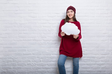 Plakat Young girl with cloud in her hands on brick wall background