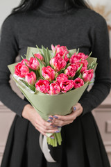 beautiful luxury bouquet of pink tulips flowers in woman hand. the work of the florist at a flower shop.