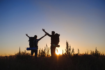 Silhouette of young couple against colorful sunset