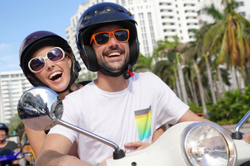 Couple having fun riding motorbike in town