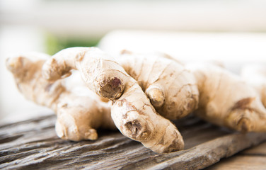 Fresh ginger on wood texture.
