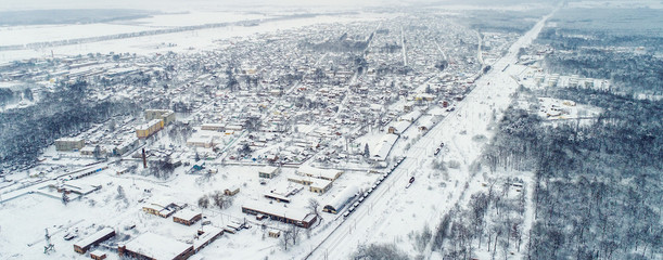 Naklejka na ściany i meble Aerial winter top down view high above rural slow living by small village
