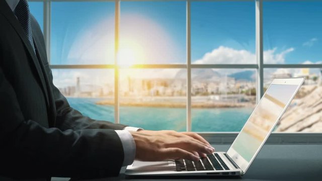 View of Alicante Spain .Close up hand Businessman using laptop