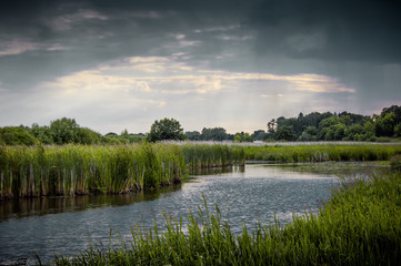summer landscape with a river and thunderclouds, open countryside