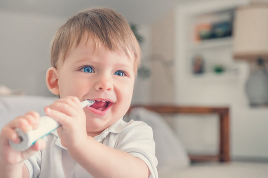 Cute little boy brushing his teeth in the room