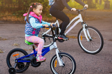 Naklejka premium Mother and daughter were cycling at the park