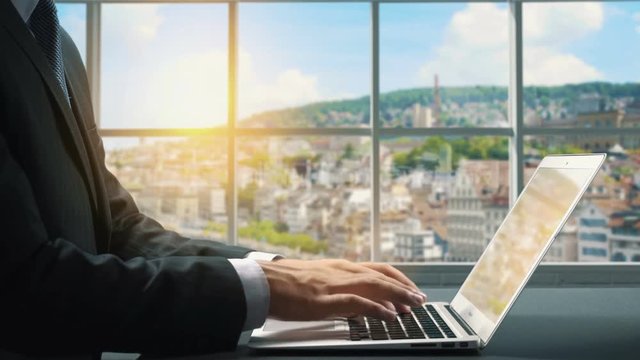 View of Zurich Switzerland.Close up hand Businessman using laptop