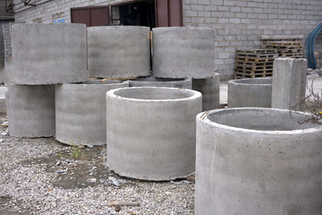 Concrete ring wells with different diameters and gray lie in the street .