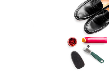 Shoe care products. Leather men shoes, shoe polish, brushes, wax on white background top view copy space