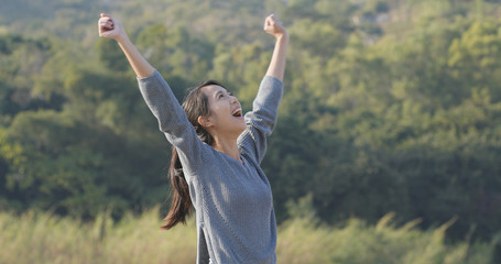 Excited woman raising hand up