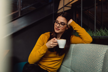 Portrait of a beautiful young brunette woman enjoying coffee.