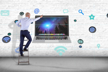 Businessman in front of a wall with a computer surrounding by app and social icon - 3d render