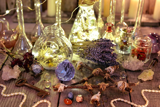 Witch magic collection with lightning bottles, crystals, pentagram, old key and herbs. Occult, esoteric, divination and wicca concept. Halloween background with vintage objects 
