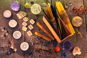Fototapeta na wymiar Ancient runes, candles, crystals, herbs and magic ritual objects on planks. Occult, esoteric, divination and wicca concept. Halloween background with vintage objects 
