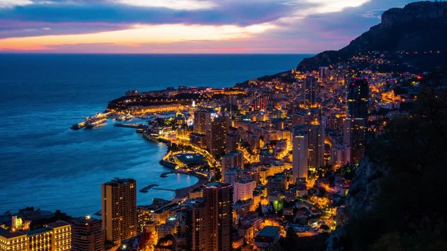 Monte Carlo, Monaco: urbanscape with city and marina in the evening. Panoramic view on Monte-Carlo from evening to night time lapse.