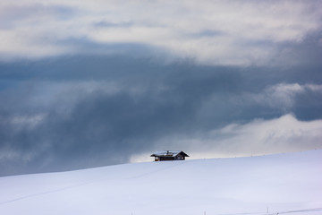 Fototapeta na wymiar Hut in the snow. Magic atmosphere in the Dolomites