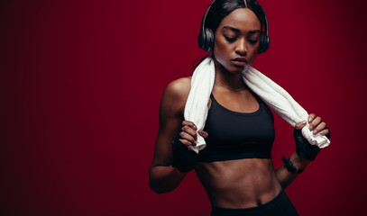 African female athlete listening music after workout - obrazy, fototapety, plakaty