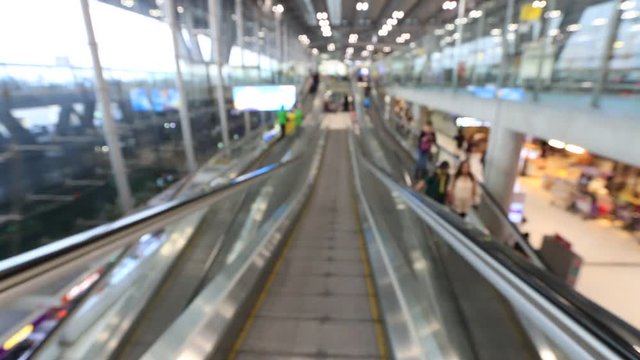 Blur View From people moving escalator In airport gate, moving standing on sidewalk. Defocused footage