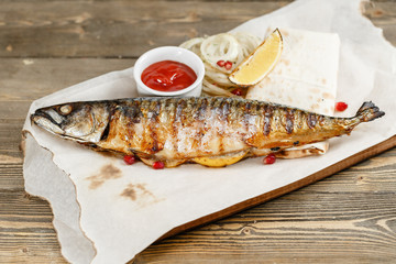 grilled mackerel. Serving on a wooden Board on a rustic table. Barbecue restaurant menu, a series of photos of different meats anf fish