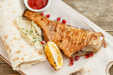 sea bass grill. Serving on a wooden Board on a rustic table. Barbecue restaurant menu, a series of photos of different meats