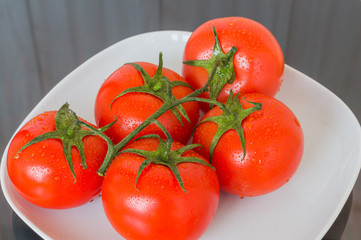 Fresh cherry tomatoes on wood background.
