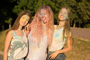 Three emotional blonde women friends celebrating Holi festival