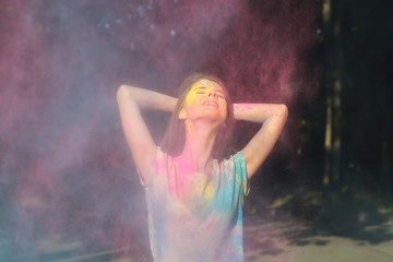 Adorable brunette model posing with Holi powder exploding around her