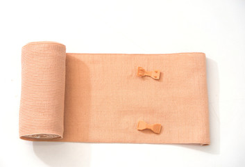 orange elastic bandage roll and hooker on white background
