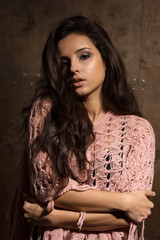 Fototapeta premium Sexy brunette model with long lush hair and professional makeup posing at the dark background