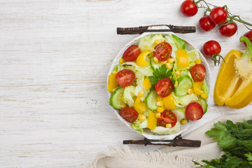 Vintage bowl with vegetable salad on wooden table, top view