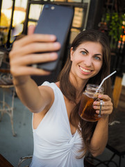 smiling woman making selfie with a drink on a party