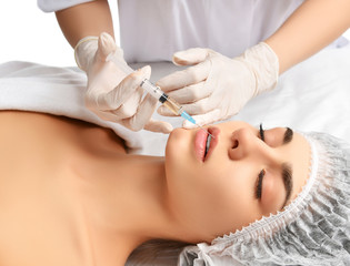 Plastic surgery beauty concept young brunette woman face and  doctor hand in glove with syringe