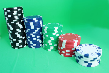 Poker concept. Bright different chips in a row, rating. Green background