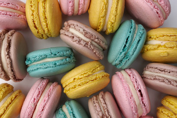 Pink, beige and blue macaroons, flat lay style. Colorful almond cookies. Pastel cake macarons background.