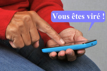 Personne envoyant vous êtes viré par SMS avec un smartphone 