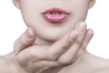 Close up of a beautiful young woman with full pink lips sending kiss with white background - photo with selective focus