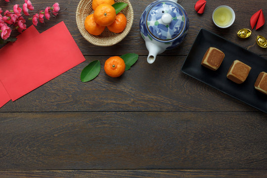 Table top view aerial image of decorations Happy Chinese New Year & Lunar festival holiday background concept.Flat lay food & drink on modern rustic brown wooden at home office desk studio.copy space.