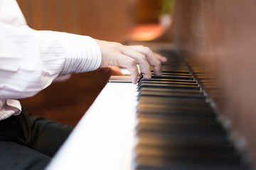 A pianist hand on piano keyborad. A pianist is playing a song at the church.